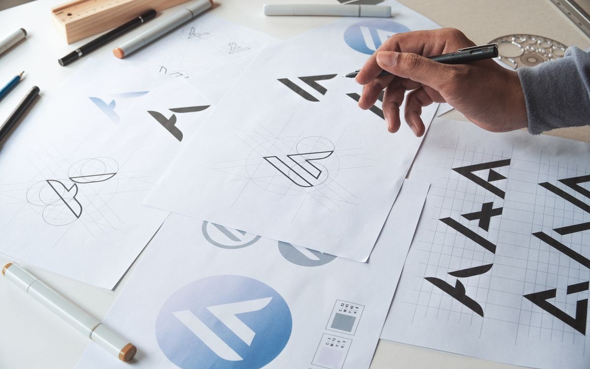 Graphic designer drawing sketch design creative Ideas draft Logo product trademark label brand artwork. Graphic designer studio Concept. Graphic designer drawing sketch design creative Ideas draft Logo product trademark label brand artwork. Graphic designer studio Concept.